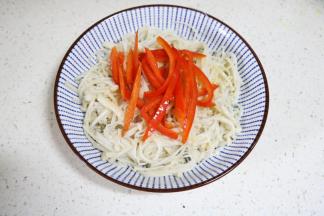 金针菇装盘，放上炒好的红椒