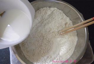 一点点倒入牛奶，一边倒一边用筷子搅拌面粉成面疙瘩状；
