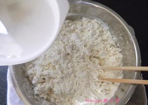 在一点点加入凉开水，继续用筷子搅拌面粉成面疙瘩；