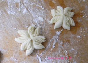 用剪刀在四瓣的每一片上剪一下，如图所示，做好的菊花卷在室温下醒发30至40分钟（夏季室温较高，醒发时间可以缩短）；