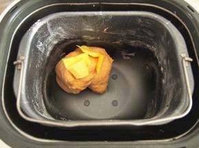 加入黄油，继续开启一个揉面程序，揉好后放入容器中包上保鲜膜进行发酵。