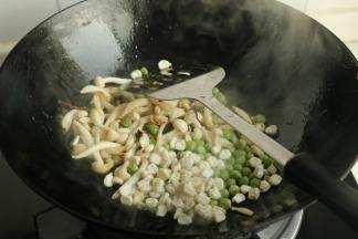 下入豌豆和玉米翻炒。