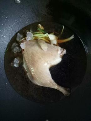 加入葱，姜片，料酒3茶匙，生抽2-3茶匙，冰糖50克，翻炒几下，加入开水，水的用量淹没鸭腿即可，大火烧开，小火焖煮45分钟左右
