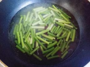 锅中加入清水，大火烧开，滴几滴有，少许盐，倒入切好的蒜薹焯水1分钟即可，捞出过冷水，淋干水份。