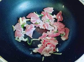 平底锅中加入适量油，油温7成时加入葱姜蒜炒香，再加入切好的肉片中火煸炒。