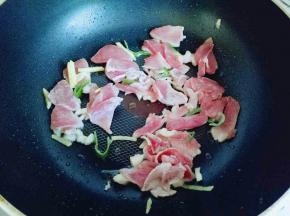 平底锅中加入适量油，油温7成时加入葱姜蒜炒香，再加入切好的肉片中火煸炒。