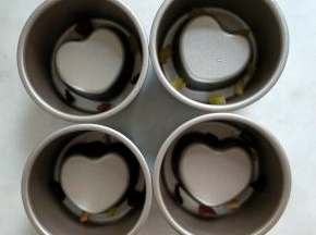 将泡开的洛神花和水果粒放在模具底部。