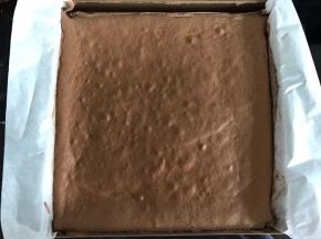 出炉后可以轻触蛋糕表面，如果是硬的有韧性就烤熟了。放至表面不再冒热气，倒扣脱模，撕去油纸，放凉。