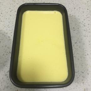 吐司盒内壁抹上一点融化的椰子油，把蛋糕糊从距离桌面20cm的地方慢慢倒入吐司盒中