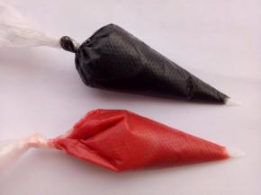 竹炭粉加一点点水搅匀，水不要放太多，取一点蛋糕糊拌匀。再用另一个碗取一点蛋糕糊用红色色素调色。（你也可以用红曲粉，同样加一点水搅匀，加一点蛋糕糊拌匀，但是红曲粉的颜色不是那么鲜艳）把调好的红色和黑色糊装入裱花袋里