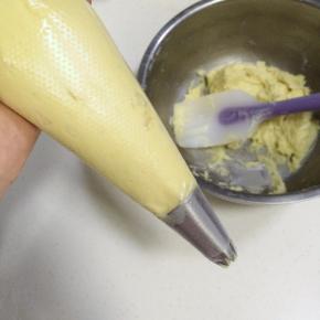 在裱花袋中装入裱花嘴，把面糊装入裱花袋中。