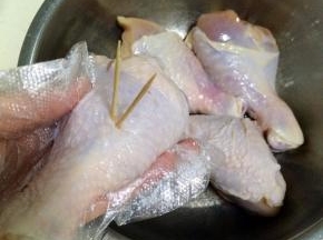 用牙签在鸡腿上扎孔。