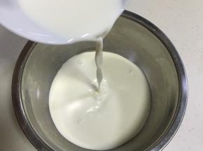 在不锈钢容器内加入淡奶油和牛奶。