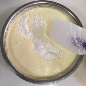 分两次加入事先过筛好的低筋面粉，用刮刀进行翻拌。