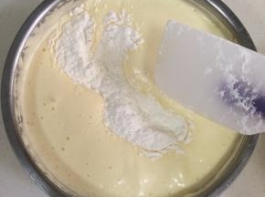 分两次加入事先过筛好的低筋面粉，用刮刀进行翻拌。
