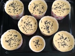 倒入纸杯中，面上可以撒些黑芝麻。入预热好的烤箱中层，上下火180度20分钟左右。