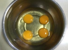 在打蛋盆内打入4个鸡蛋。