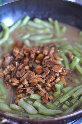 打开锅盖，将肉倒在豆角上面拌匀。