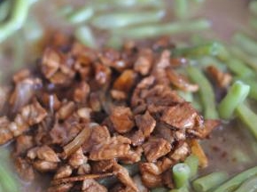 打开锅盖，将肉倒在豆角上面拌匀。