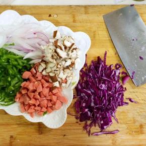 把紫甘蓝、蘑菇、洋葱、青椒和香肠切好备用。