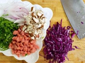 把紫甘蓝、蘑菇、洋葱、青椒和香肠切好备用。