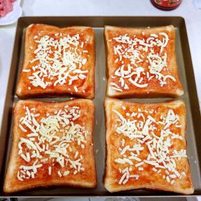 在吐司上抹上番茄酱，撒上适量的马苏里拉奶酪。