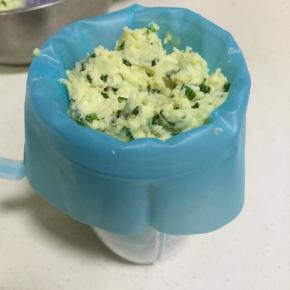 把裱花嘴装入裱花袋中，接着把曲奇面糊装入裱花袋中。