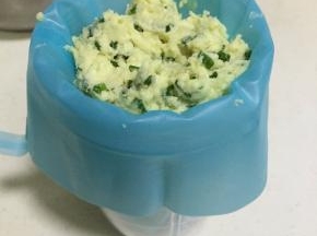 把裱花嘴装入裱花袋中，接着把曲奇面糊装入裱花袋中。