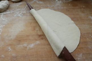 用擀面杖卷起来，一点点推开，转着圈推开。