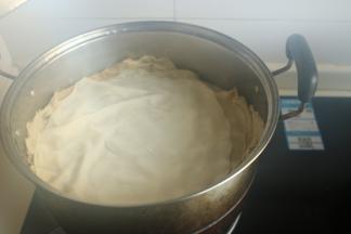 盖上盖子蒸，然后开始擀下一个饼，擀好之后，再打开盖子把饼摞在上面继续蒸。