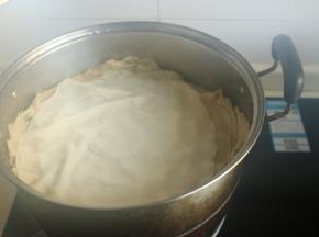 盖上盖子蒸，然后开始擀下一个饼，擀好之后，再打开盖子把饼摞在上面继续蒸。