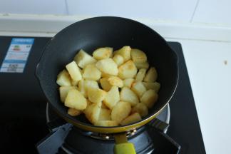 下入切好的熟土豆块，煎至表面金黄。