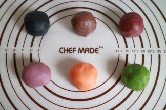 油酥材料也混合揉成团，然后分成六份，分别加入竹炭粉、可可粉、红曲粉、紫薯粉、黄金芝士粉、抹茶粉