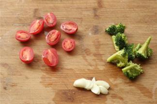 圣女果选择小一点的，切两半，西兰花拆分成小朵，蒜切片。