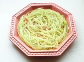 沥干一下水分，把青笋丝铺在盘子底部。