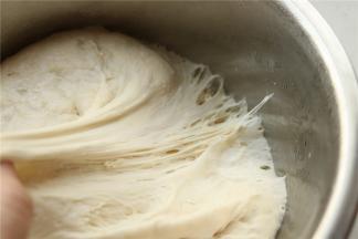 第二天取出发酵好的面团，检查一下，可以看到拉开后孔洞明显。