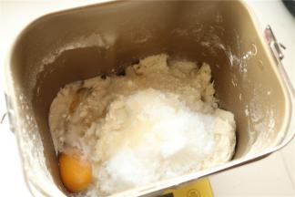 加入除了黄油和芝麻之外的主面团材料到面包机里，开启面包机揉一个面团程序，我的机子是15分钟，面包机揉面的时候炒香黑芝麻，2分钟左右就行，能听到噼里啪啦的声音时候关火，继续搅拌至冷却至室温。