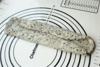 取一份面团，擀开成长条，两边折起，按平。