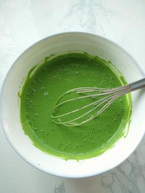 再来制作抹茶奶冻。先将吉利丁片泡在冰水中10分钟至软备用。希腊酸奶中加入抹茶粉，搅打均匀，再加入蜂蜜，拌匀。