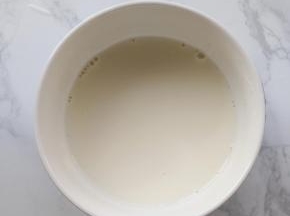 泡好的吉利丁片沥干水分，隔水加热至完全溶化，再加入淡椰浆，搅拌均匀。