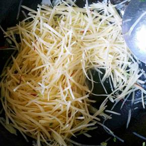 出香味儿后加入土豆丝翻炒。