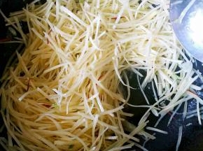 出香味儿后加入土豆丝翻炒。