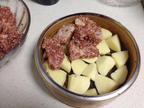 土豆加少许盐拌匀摆在蒸茏里，将排骨铺在土豆上面。