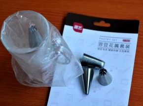 3、将展艺的溶豆裱花嘴放入裱花袋中，把嘴口折叠向上，套在玻璃杯上