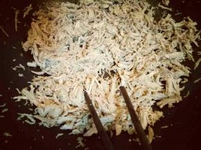 撕好的肉丝倒入锅中，加入生抽，用筷子不停的翻炒，把水份炒干。