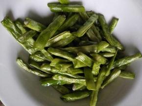 四季豆先泡水洗净沥干，过油（就是把洗净的四季豆在油锅里炸一会）