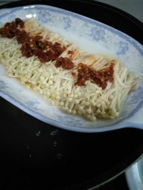 锅中烧开水，放入摆好的金针菇，大火，金针菇稍微变软，加入剁椒