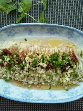 锅中已经蒸好的金针菇拿出来放一旁冷一会，香葱撒在金针菇上，放入一点点生抽。再把大蒜老姜铺在上面即可（全程不要放盐）