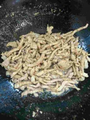 锅烧热倒入适量的油，放入腌制好的肉丝快速翻炒均匀至肉丝变色。

