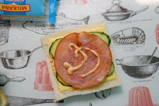 摆上青瓜片再放上一片火腿片，挤上少量千岛酱